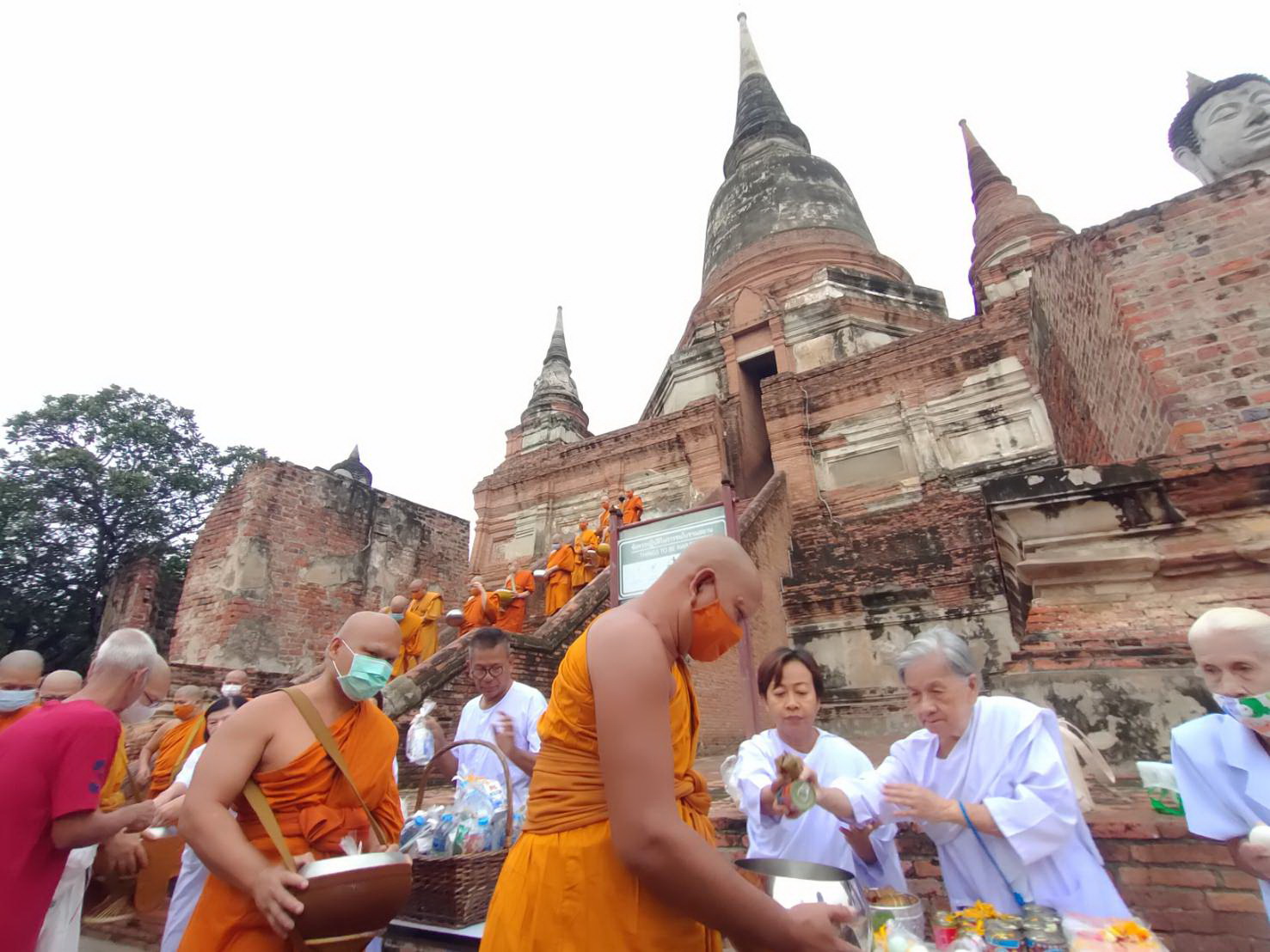 พระสงฆ์เดินลงจากโบราณสถานพระเจดีย์ชัยมงคลสืบสานประเพณีตักบาตรเทโว